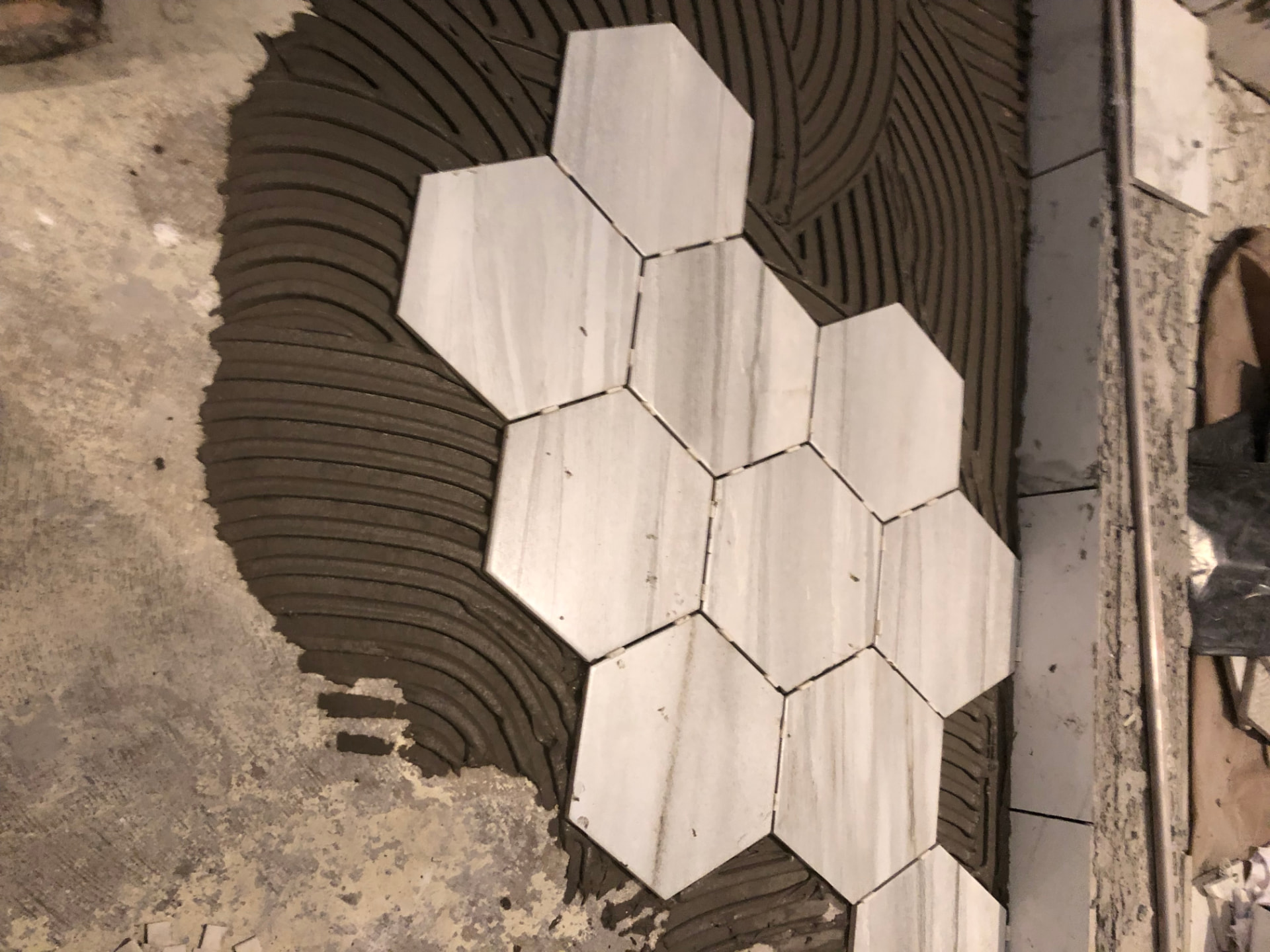 Hexagonal floor tile being set in mortar