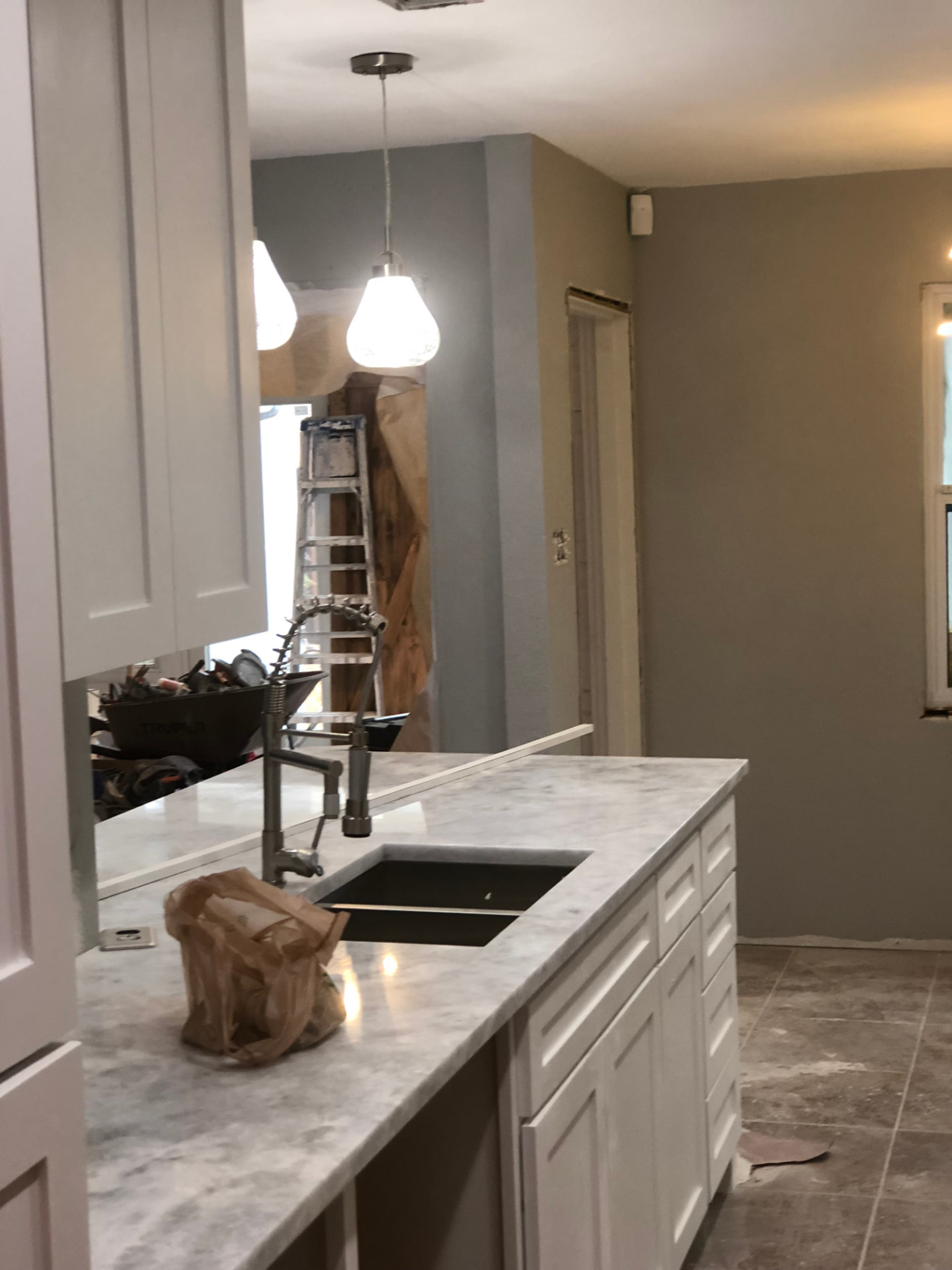 Renovated kitchen island with pendant lighting and cabinetry